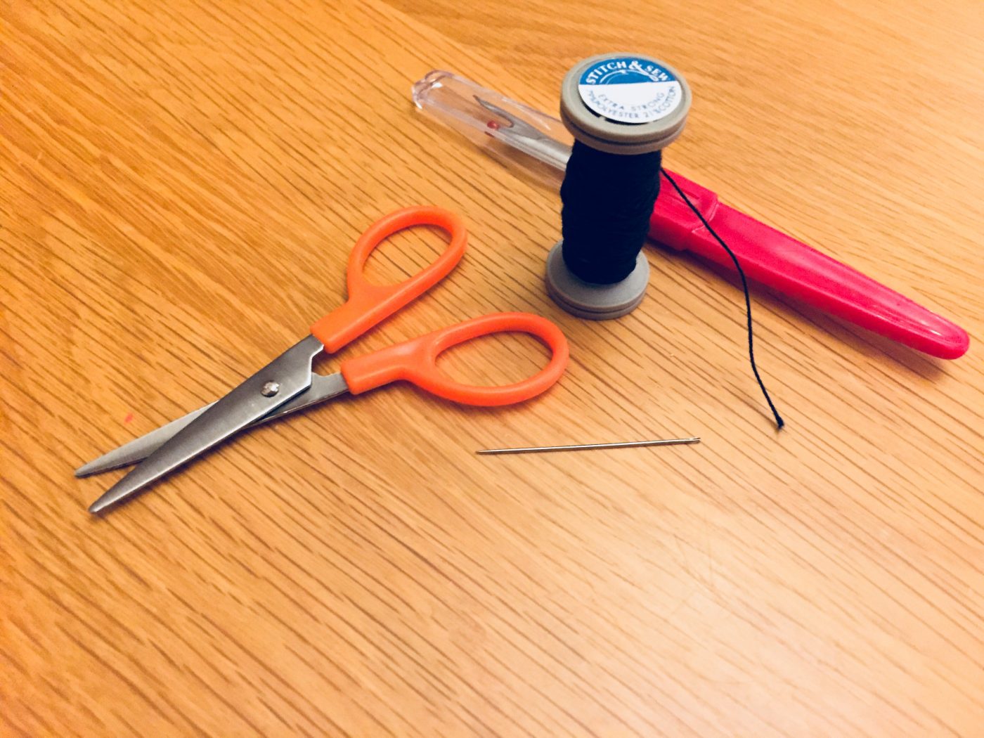 Sewing scissors, needle and thread